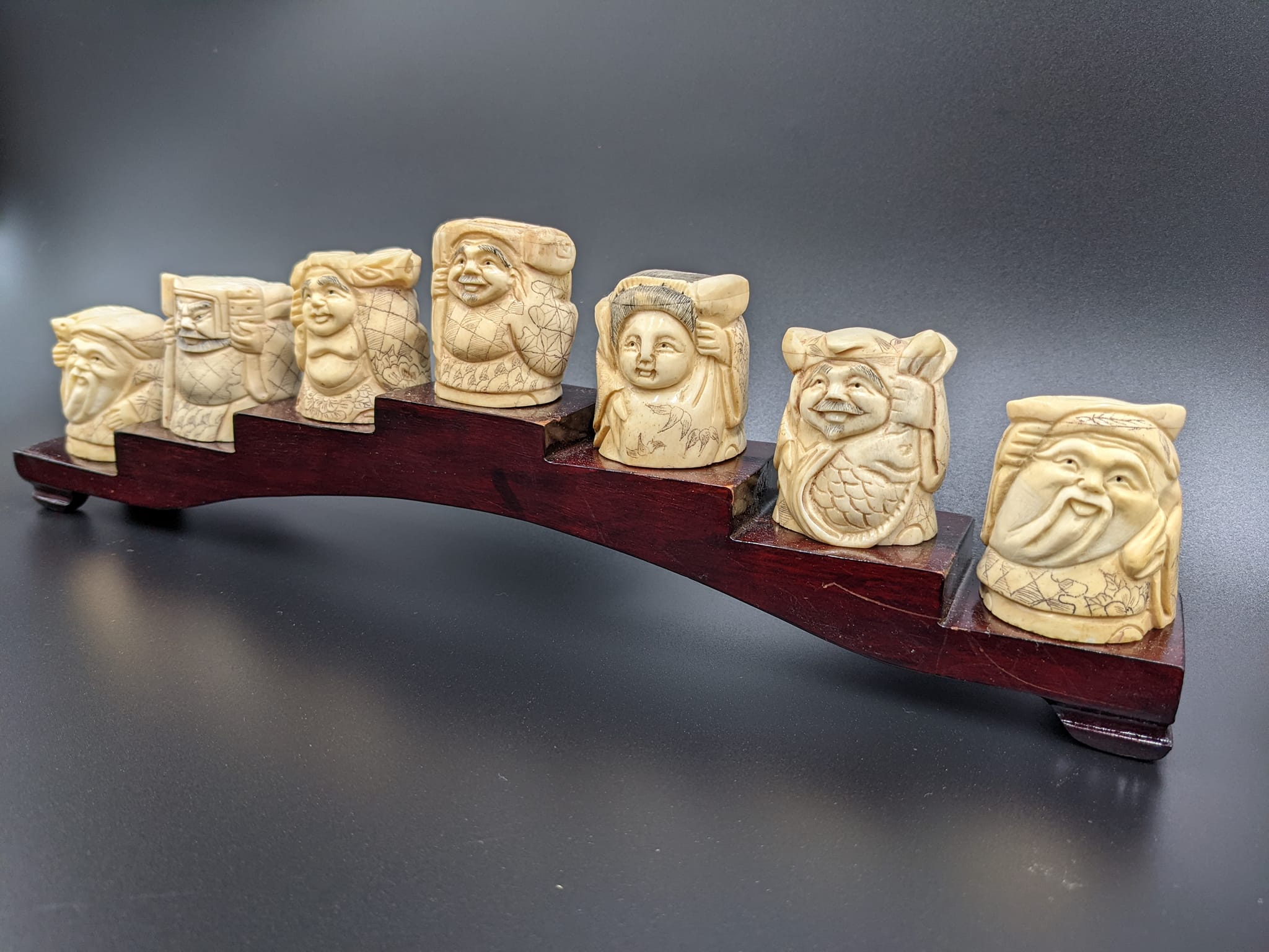 A group of small carved figurines displayed against a dark background